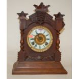 A late 19th century oak cased mantel clock by The Ansonia Clock Company of New York having an