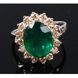 A contemporary 14ct white gold, emerald and diamond cluster ring,