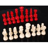 A turned ivory chess set, one side stained red, the other left natural, early 20th century, king h.