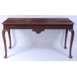 A mid-18th century walnut hall table, having a replacement top and shaped apron,