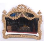 A mid-19th century French giltwood and gesso wall mirror, the bevelled plate of shaped form,
