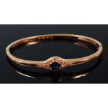 A 14ct gold, sapphire and diamond set hinged bangle,