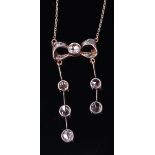A Victorian white metal diamond set pendant, arranged as a ribbon supporting three and two drops,