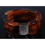 A sectional concave tigers eye expanding bracelet, with single multiple small diamond set section,