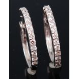 A pair of 18ct white gold hoop earrings, each half pavé set with fourteen small brilliants, dia.2.