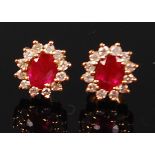 A pair of 18ct gold, ruby and diamond ear studs, as a flower head setting,