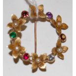 A 9ct gold precious set Regard brooch, the flower head and border set with a ruby, emerald, garnet,