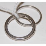 A platinum wedding band together with a white metal wedding band, indistinctly marked,
