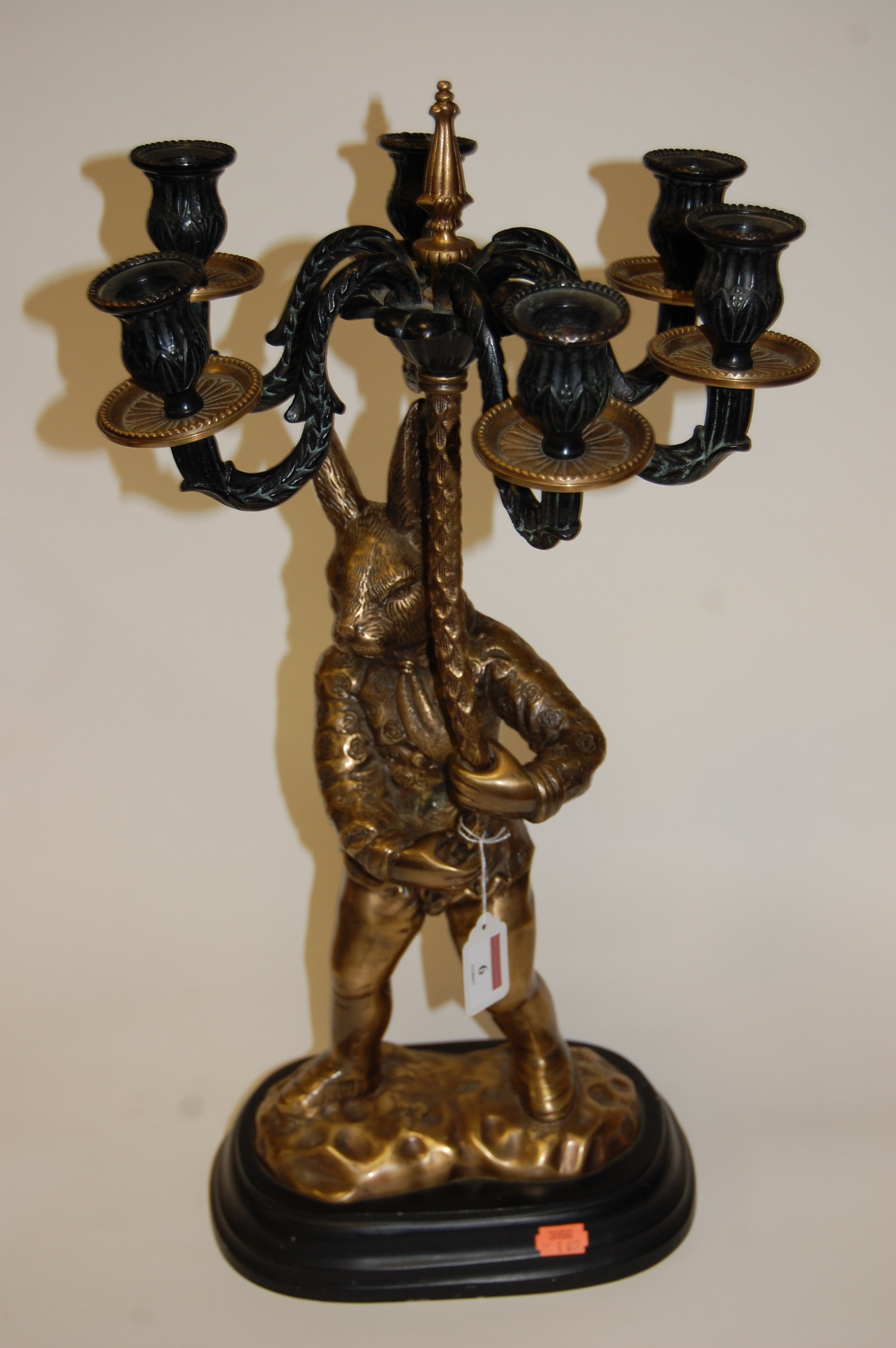 A large lacquered brass figure of a rabbit supporting a six sconce candelabra, on plinth base, h.