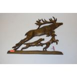 A modern pressed metal wall plaque in the form of a leaping stag and dogs