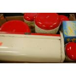 An enamel bread bin with a matching set of storage containers;