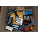 A box of various 00 gauge rolling stock and accessories