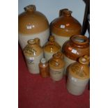 Eight various part glazed earthenware advertising flagons to include Wild & Co.