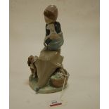 A Lladro figure of a seated girl holding a lamb with dog at her feet, impressed mark verso, h.