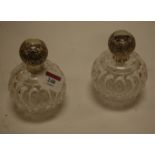 A pair of circa 1900 cut glass and silver topped scent bottles