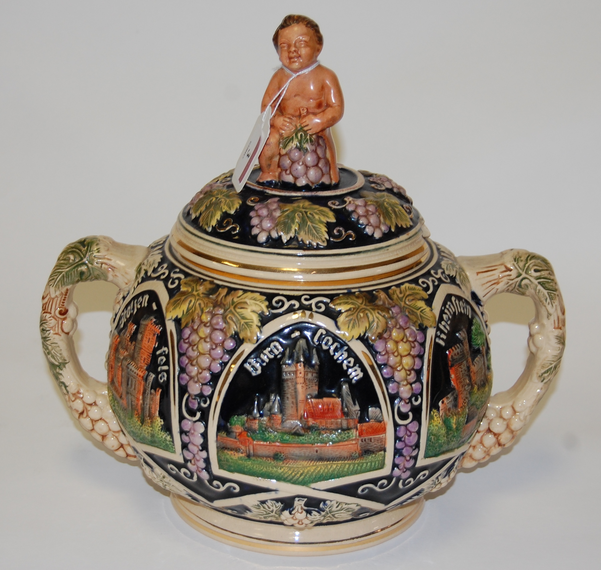 A German pottery twin handled tureen and cover, relief decorated with landmarks, h.