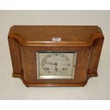 An Art Deco walnut cased mantel clock of shaped rectangular form having a silvered dial with Arabic