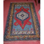 A Persian blue ground woollen rug, having trailing tramline borders,