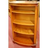 A reproduction yew wood bowfront freestanding open bookshelf,