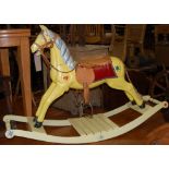 A childs yellow painted rocking horse, having tan leather studded saddle, raised on integral base,