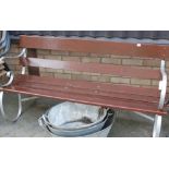 A wrought iron and wooden slatted garden bench,