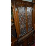 A contemporary moulded oak and lead glazed freestanding four door corner cupboard