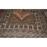 A large Persian style brown ground woollen rug,