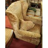 An early 20th century mahogany framed and upholstered wingback armchair