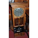 An early 20th century oak cased clocking-in and clocking-out clock,