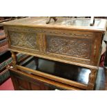 A low relief carved and moulded oak hinge-top coffer, w.