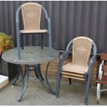 A modern glass topped metal patio table with four matching stacking chairs