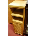 A light oak bathroom cabinet of narrow proportions,