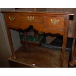 A Georgian style oak three drawer lowboy, having typical shaped apron,