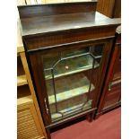 An early 20th century walnut ledgeback single door glazed china display cabinet