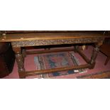 A made-up oak refectory table, having low relief floral carved frieze, raised on turned,