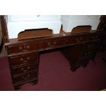 A reproduction mahogany and gilt tooled tan leather inset twin pedestal writing desk, w.