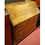 A George III oak slope front writing bureau having two short over three long drawers,