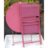 A pink painted metal folding patio table together with matching folding chair (2)
