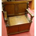 A moulded oak fold over twin panelled monks bench, having typical hinged box seat base,
