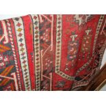 A near-pair of Turkish woollen red ground rugs