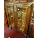 A 1930s moulded oak double door glazed bookcase, w.