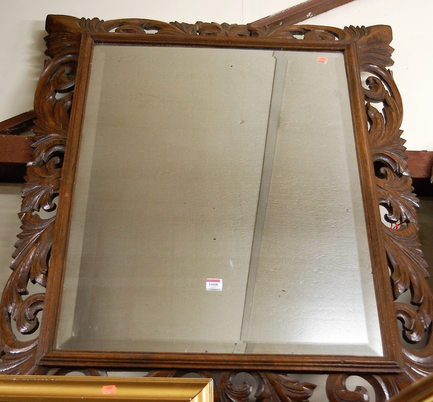 Circa 1900 carved oak framed and bevelled wall mirror,