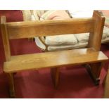 An early 20th century pitched pine two seater church pew, having integral rear shelf,