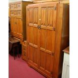 A late Arts & Crafts oak linenfold panelled bedroom suite, comprising; double door wardrobe,