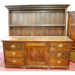 A large Victorian stained pine kitchen dresser, having a three tier open upper plate-rack,