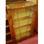 An Art Deco moulded oak ledgeback single door glazed bookcase