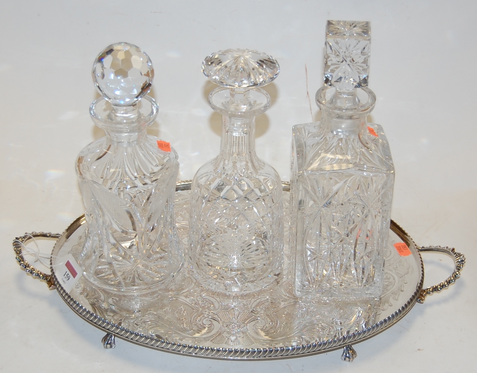 A Waterford cut glass decanter and stopper together with two others on silver plated twin handled