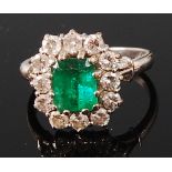 An 18ct white gold, emerald and diamond cluster ring,