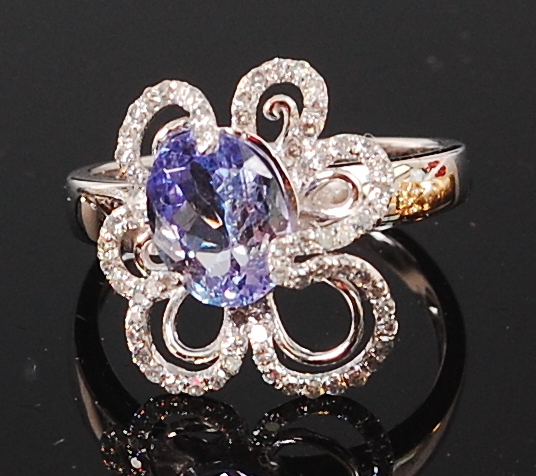A contemporary 14ct white gold and diamond ring, set with an oval cut tanzanite weighing approx 1.
