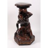 A 19th century carved walnut torchere, modelled as a Blackamoor figure, with traces of gilt,